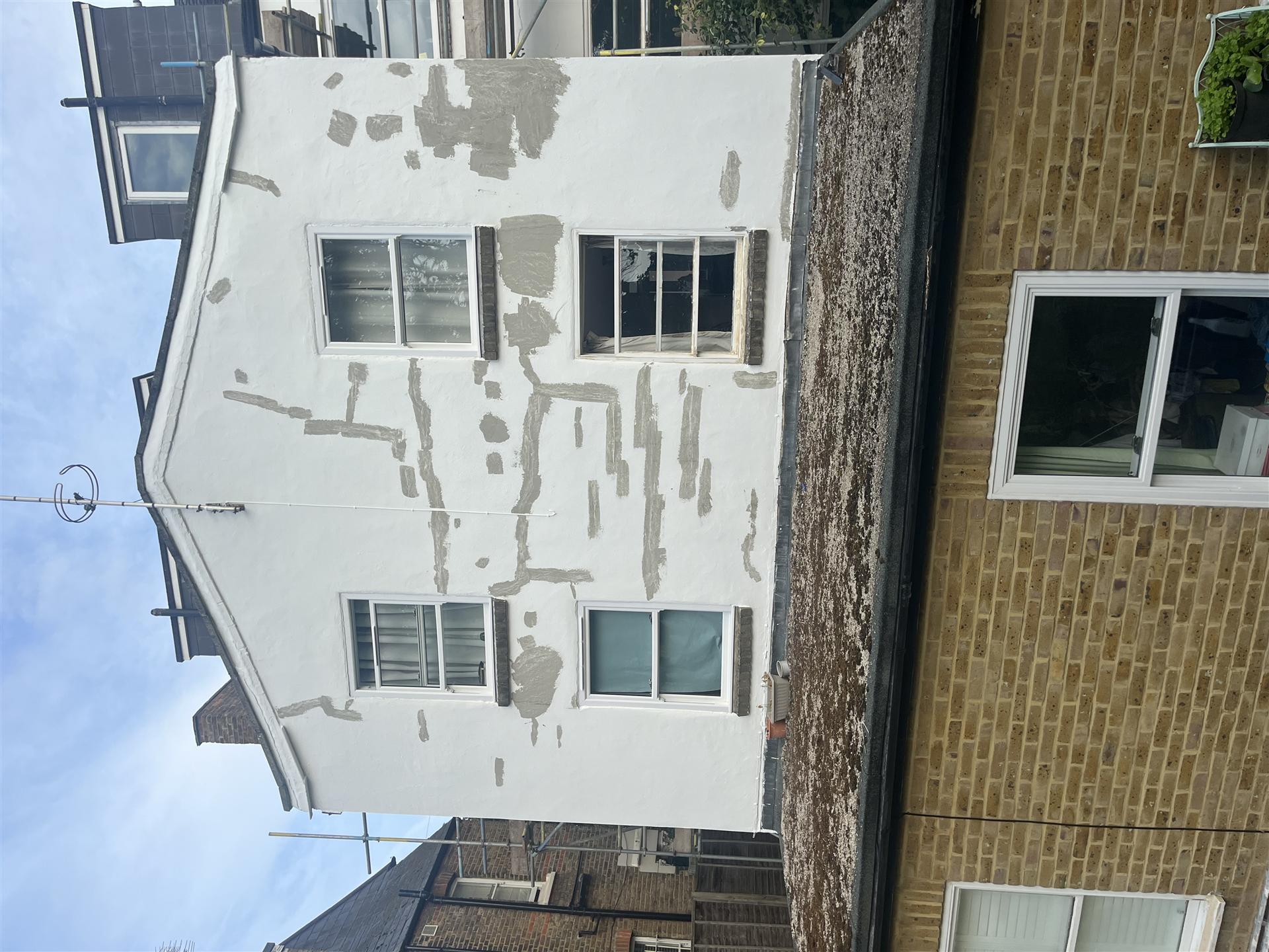 Before, rendered gable end with patchy and cracked paint, Essex
